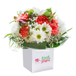 Brimming with the uplifting spirit of Wallington, this beautiful bouquet radiates a cheerful freshness that feels like a stroll through the blooming pockets around Beddington Park on a bright morning. Arranged upright in a square white gift bag, the design pairs vibrant coral and peach carnations-each one full of soft, frilled petals-with crisp white daisies featuring lively yellow-green centres. Scattered throughout, sprigs of airy white baby's breath lend an ethereal softness, blending harmoniously with the main flowers and infusing the bouquet with gentle grace. Closed buds with delicate purple highlights peek out amid the blooms, hinting at new beginnings just waiting to unfold. Glorious, broad green foliage wraps around the base, creating a natural embrace that holds the bouquet together like the welcoming community spirit along Wallington's Park Lane or Stafford Road. The sturdy white ribbon handles on the bag make it easy to present this arrangement as a gift-perfect for a birthday, a special local celebration, or simply to send a token of appreciation nearby. Bathed in clear, even lighting and set against a pure white backdrop, every detail of this carefully crafted bouquet is lovingly showcased, making it a wonderful expression of joy and thoughtful floristry in Wallington.